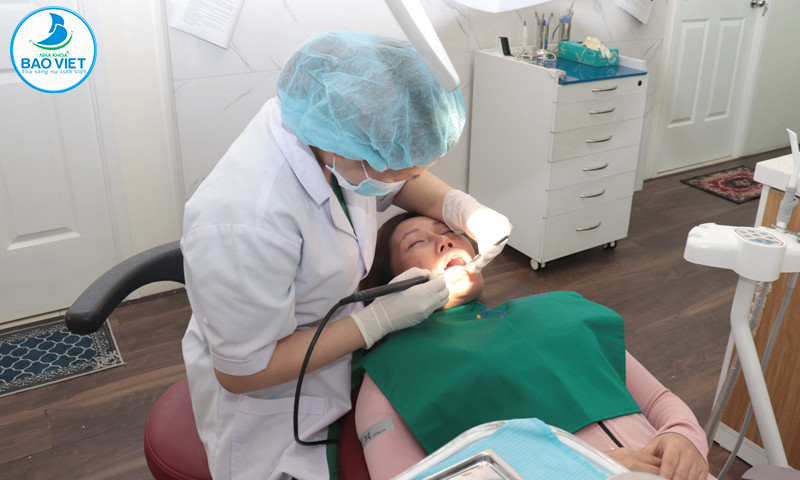 Bác sĩ đang thực hiện quy trình trám răng cho khách hàng ở Nha Khoa Bảo Việt